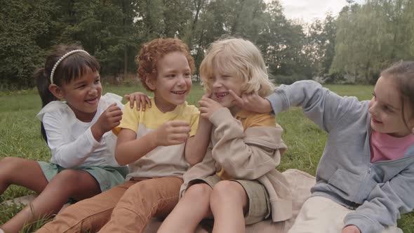 Kids Sitting on Lawn in Park