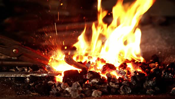 Close-up of blacksmith heating a horseshoe in fire