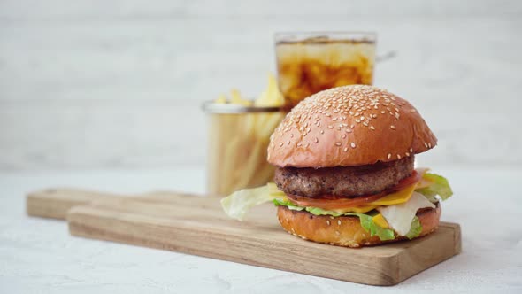 Fresh Tasty Burger Served with Soda and French Fries on White Table