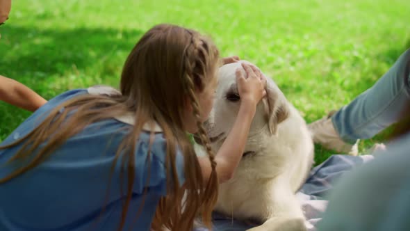 Cute Girl Hugging Labrador on Park Picnic