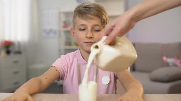 Woman Pouring Fresh Milk in Glass for Son's Healthy Breakfast, Calcium Nutrition