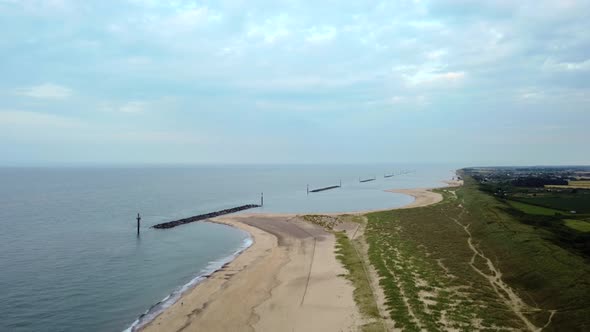 Aerial shot flying backwards over an empty beautiful beach on a UK coastline