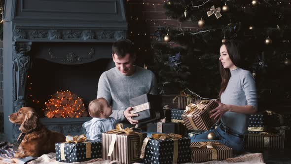 Family with Dog Unpacking Cristmas Gifts at Home