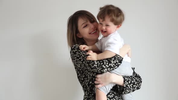 Mother with son on white wall background in home