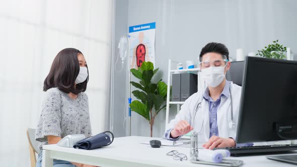 Asian specialist male doctor wear mask, explain diagnosis to young girl patient during appointment.