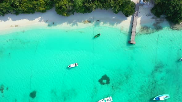 Daytime flying copy space shot of a white sand paradise beach and aqua blue water background in best