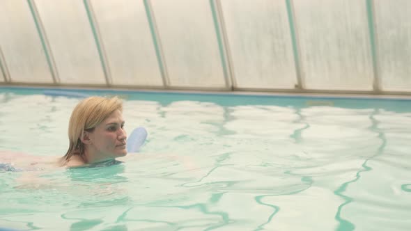 The woman swims in the pool. Swimming is good for health