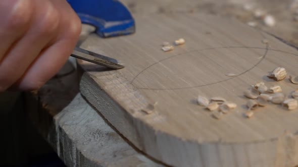 Chiseling wood blank with design pattern to make a furniture décor piece, Close up shot