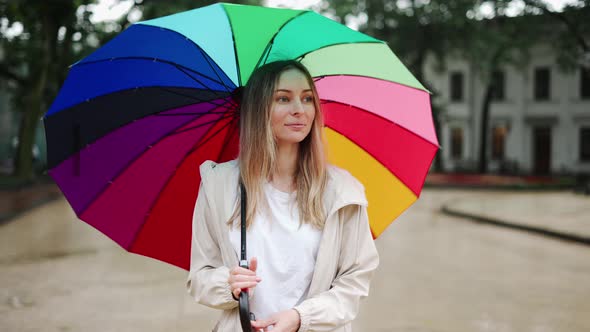 Portrait of a Woman Spinning Multicolored Umbrella on the Street