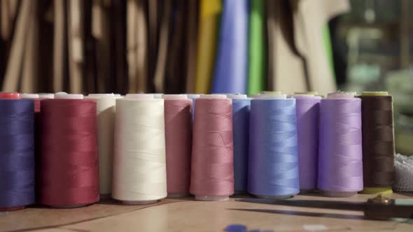 Reels with Colored Threads on the Table in the Studio