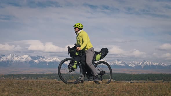 The Man Travel on Mixed Terrain Cycle Touring with Bikepacking. The Traveler Journey with Bicycle