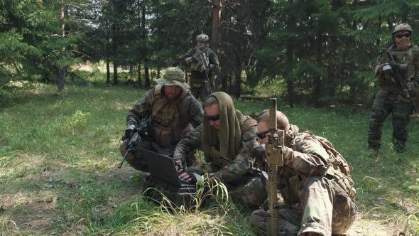 Soldiers With Laptop During Operation In Jungle alt