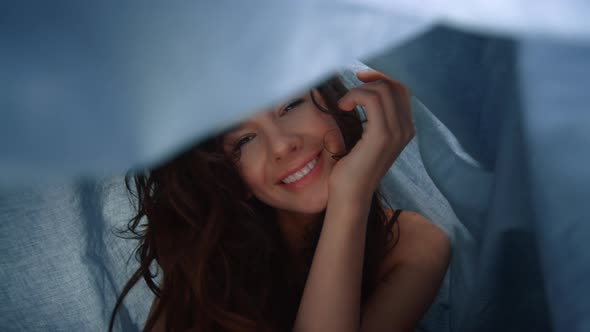 Cute Girl Having Fun Under Cloth. Sweet Woman Posing Camera in Fabric Background