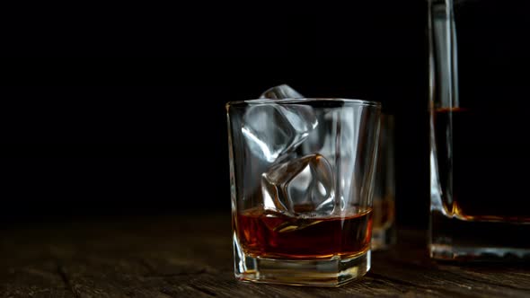 Super Slow Motion Shot of Ice Drop Into Glass with Whiskey at 1000Fps with Camera Movement.