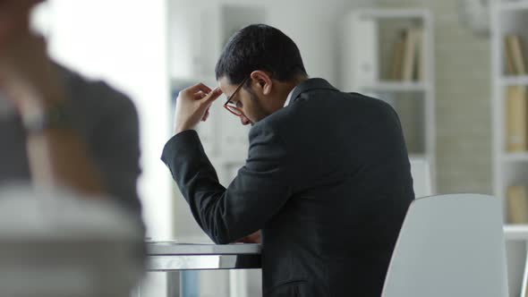 Businessman Using Gadget at Desk in Office