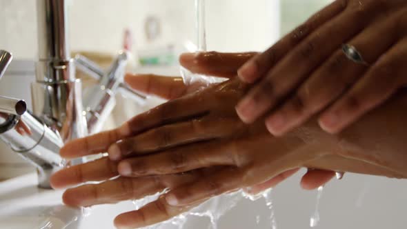 Mother and daughter washing hands in bathroom sink 4k