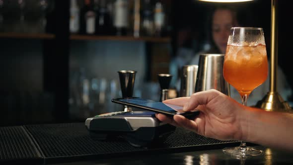 Closeup of Woman Making Payment Through NFC in Bakery Cafe Restaurant Bar for Cocktail Lemonade