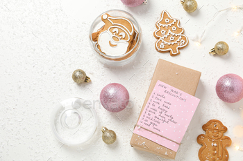 Cookies and paper with list on box on white background, top view