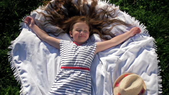 Child Lying on Blanket Having Picnic in Summer Park