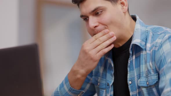 Closeup of Focused Handsome Young Businessman Thinking and Messaging Online on Laptop