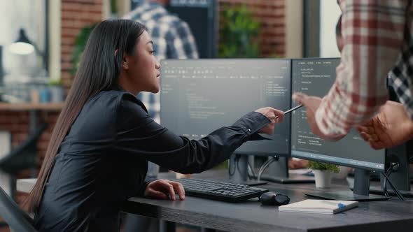 Database Developer Pointing Pencil at Computer Screen with Software Compiling Code Explaining Source