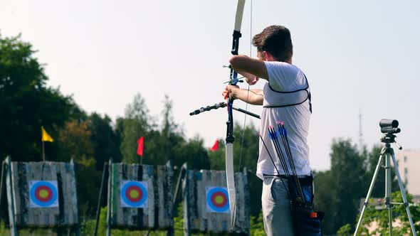 Male Athlete Aiming at Target with a Bow