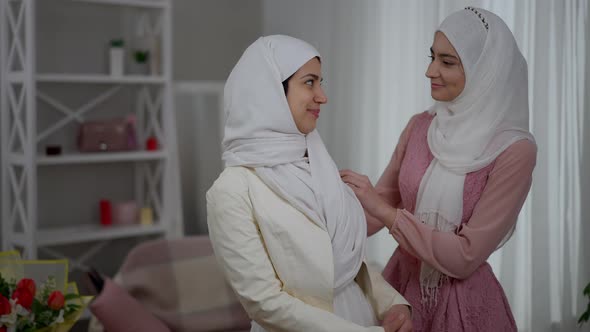 Portrait of Muslim Middle Eastern Woman in White Hijab and Wedding Dress Standing Indoors with