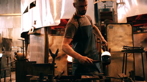 Glassblower shaping a molten glass