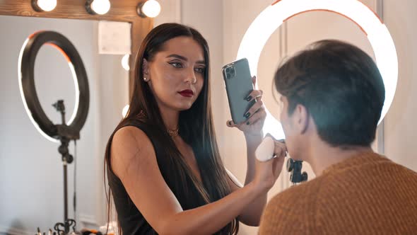 Make Up Artist Taking Photos of Male Model with Makeup on - Adding Finishing Touches