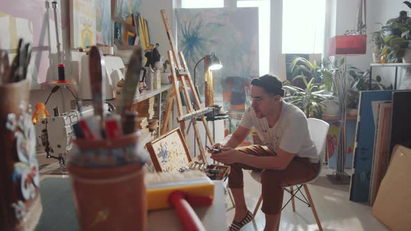 Man Sharpening Pencil in Art Studio