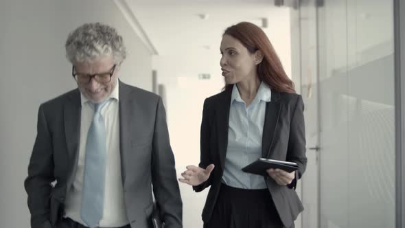 Happy Manager and Boss Talking While Walking in Office Corridor