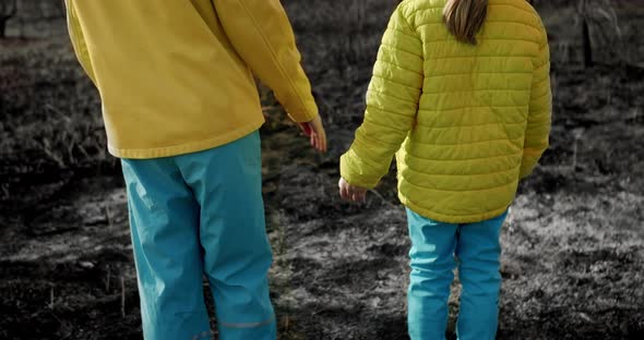 The younger sisters, dressed in the colors of the Ukrainian flag holding hands