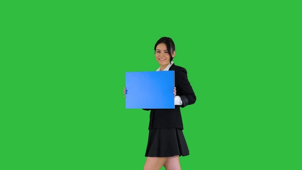 Cute girl holding empty board announcing or presenting