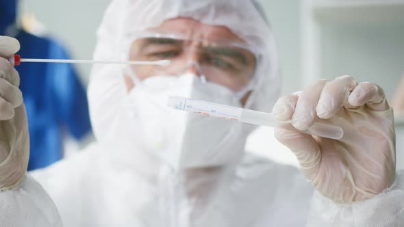 Closeup of PCR Test Doctor Looking at Coronavirus Swab Collection Kit Lab Worker Wearing PPE