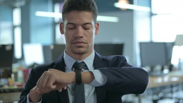 Portrait of Cheerful African Businessman Using Smart Watch