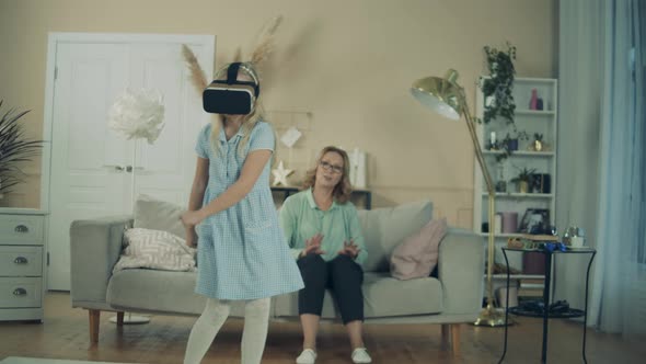 Little Girl Is Wearing VRglasses and Dancing Next To Her Granny