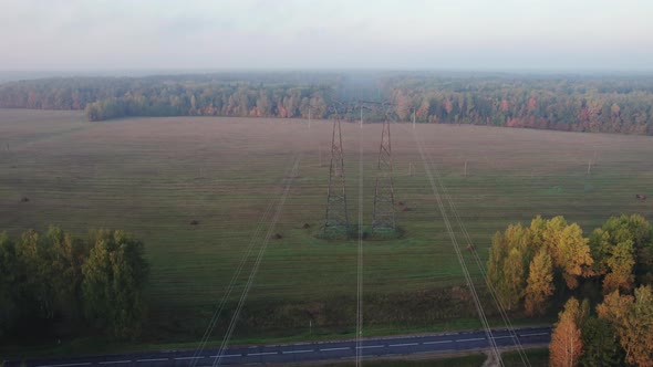 Power Line Wires Stretched Across the Field Towards the Forest