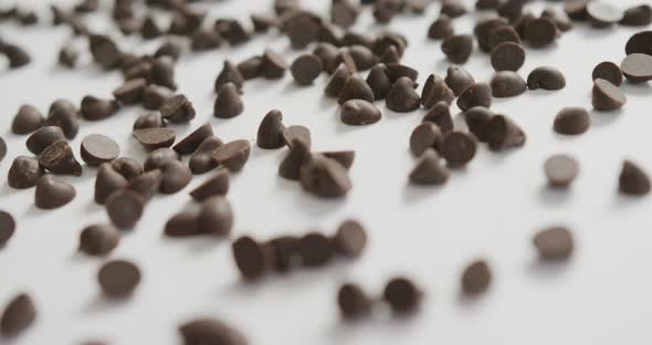 Video of close up of multiple chocolate chip over white background