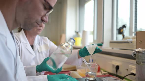 Scientist in laboratory filtering liquid through funnel