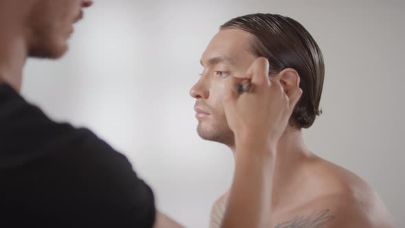Male Make-Up Artist Putting Bronzer on Male Client
