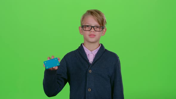 Child Boy with Glasses Looked at Credit Card and Showed Dislike on a Green Screen