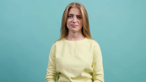 Young Bored Woman Make Blah Blah Gesture with Hand, on Turquoise Background