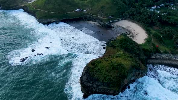 Paradise beach hidden between volcanic rocks on Kasap coast, Java, Indonesia, aerial