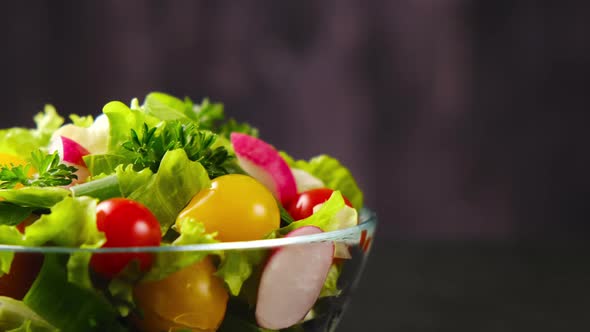 Fresh vegetable salad from cucumber, tomato and lettuce on black background