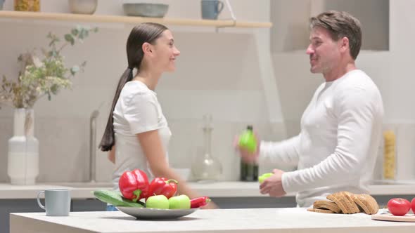 Happy Mixed Race Couple Dancing in Kitchen