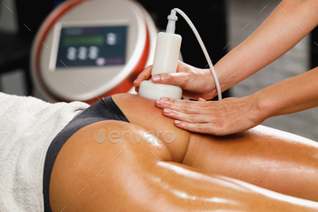 llulite massage at the beauty salon. She have an ultrasound cavitacion treatment to fat reduction.