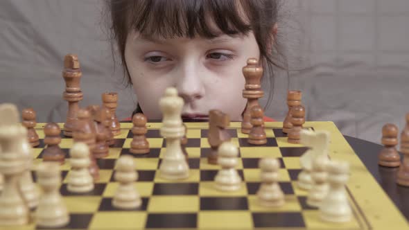Pensive Child By Chess Board at Home