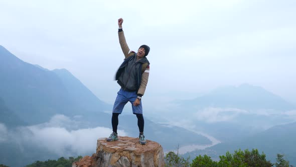 Asia Male  Jumping On Top Of Mountain