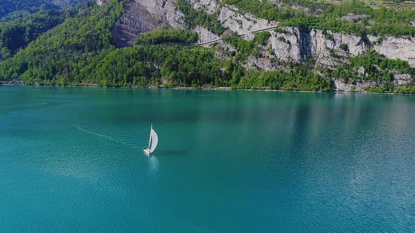 Aerial video of a sail boat cruising along Walensee Lake in Switzerland during Summer (1)