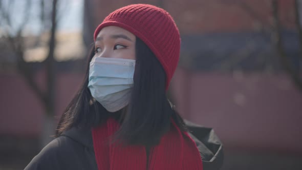 Young Asian Woman in Coronavirus Face Mask Looking Around Standing in Countryside
